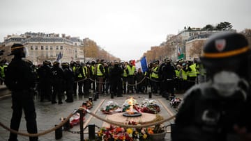 Sicherheitskräfte beaufsichtigen die Demonstranten am Triumphbogen in Paris: Hier ist die Stimmung noch friedlich...