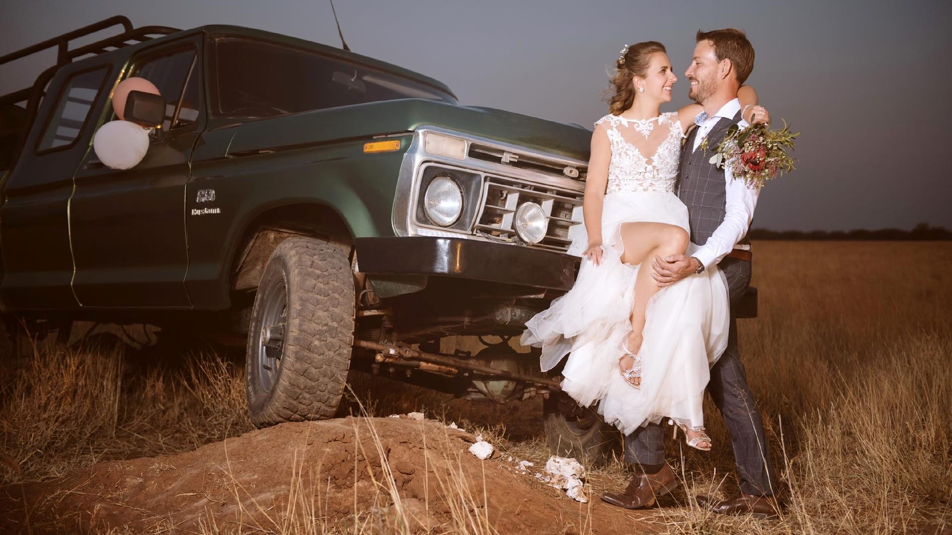 Ein etwas anderes Hochzeitsfoto: Anna und Gerald posieren in den Weiten Namibias vor einem Jeep.