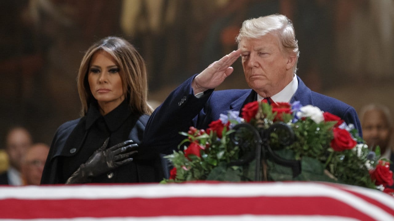 US-Präsident Donald Trump salutiert an dem mit einer Fahne verhüllten Sarg.