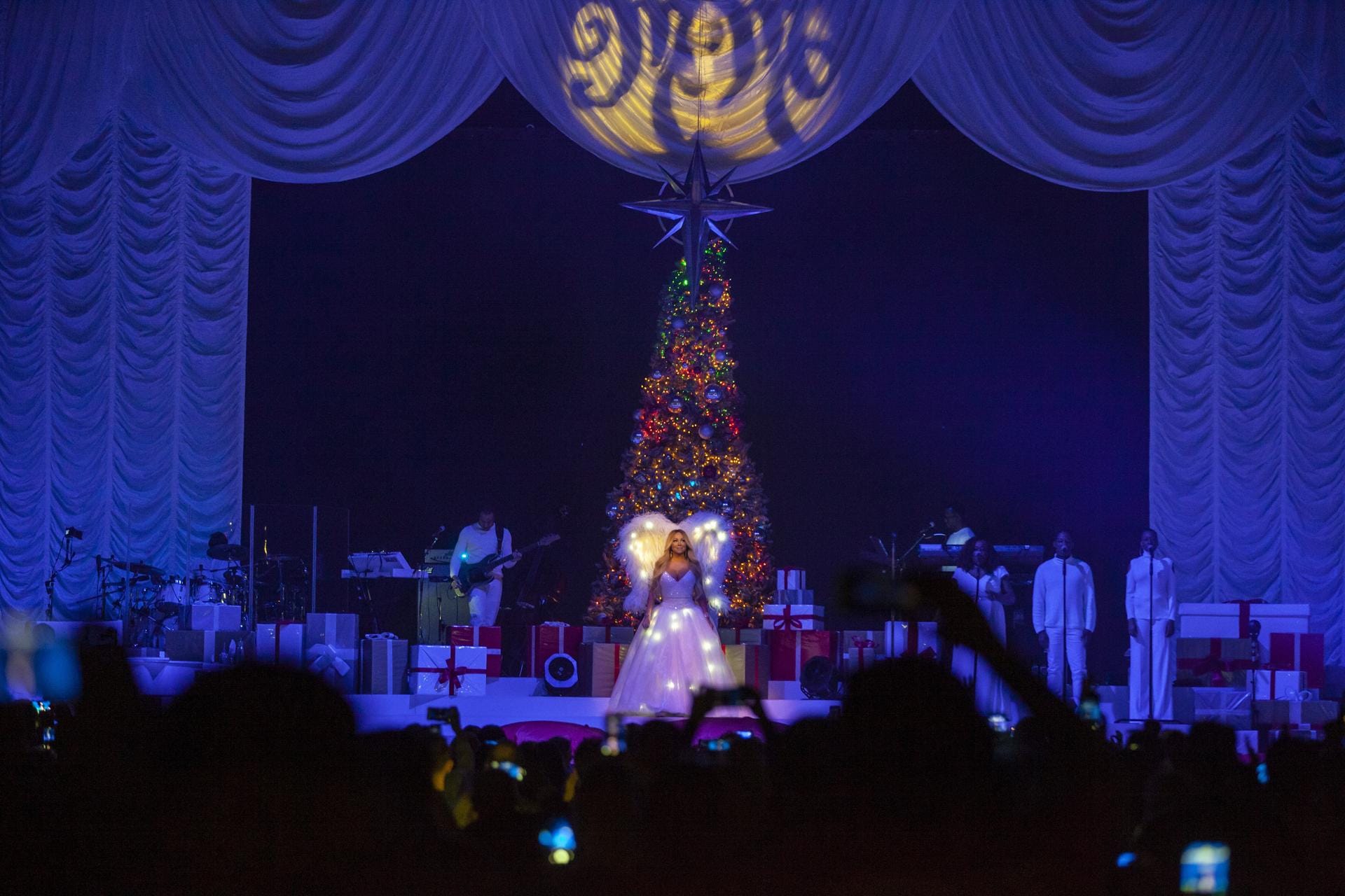Mariah Carey in Berlin: Zu Beginn des Konzertes steht Maria Carey mit Engelsflügeln und beleuchtetem Kleid auf der Bühne.