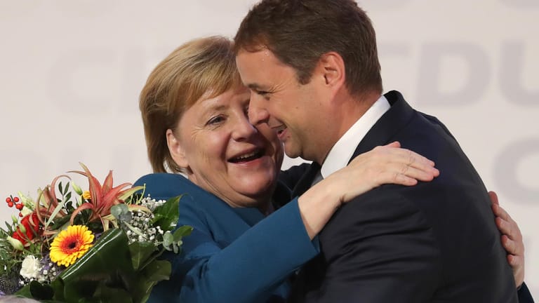 Blumen zum Abschied: Kanzlerin Angela Merkel und der mecklenburgische CDU-Landesvorsitzende Vincent Kokert nehmen sich in den Arm.