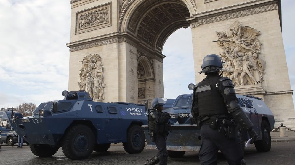 Polizisten und Räumpanzer vor dem Pariser Triumphbogen.