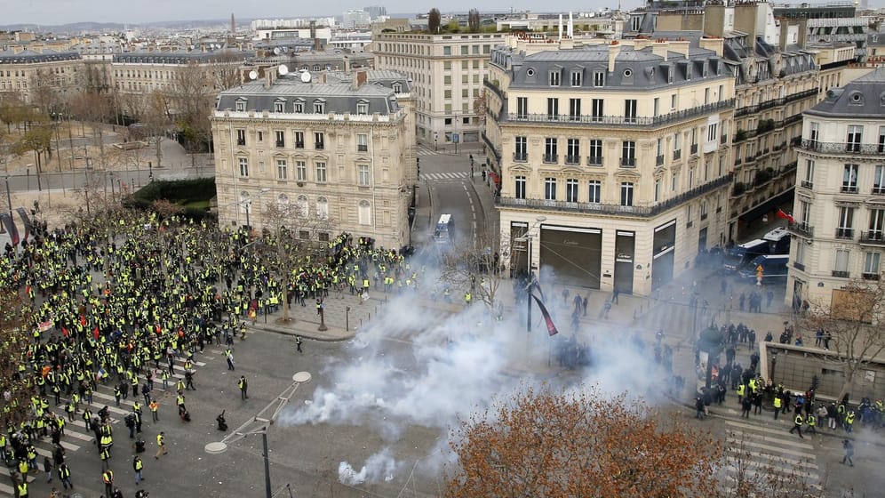 Polizisten setzen Tränengas gegen Demonstranten in Paris ein.