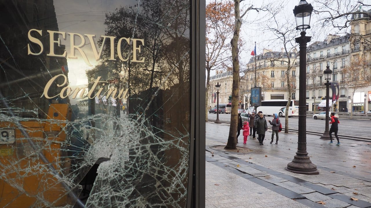Eine zerborstene Glasscheibe eines Lokals auf der Pariser Prachtstraße Champs-Elysees.