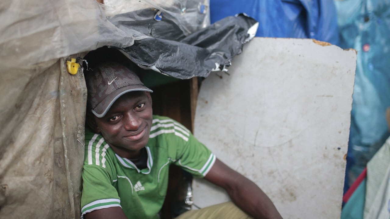 Wazzizi, ein Migrant aus Guinea, sitzt vor dem Zelt, in dem er im Lager Ouled Ziane in Casablanca, Marokko lebt.