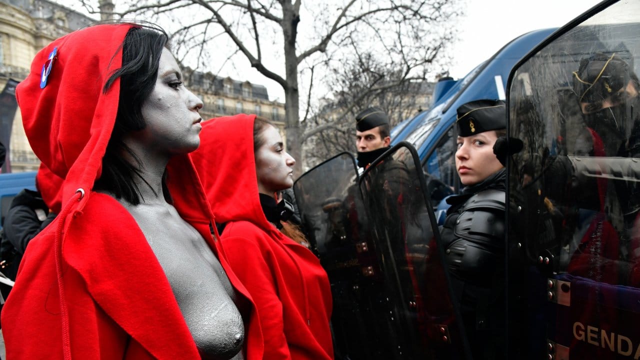 Aktivistinnen, die wie Marianne, das Symbol der Französischen Republik, gekleidet sind, stehen bei einem Protest der "Gelbwesten" in Paris Polizisten gegenüber.