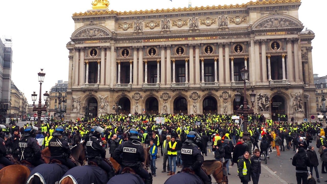 Polizisten auf Pferden stehen vor der Pariser Oper Hunderten demonstrierenden "Gelbwesten" gegenüber. Polizisten auf Pferden stehen vor der Pariser Oper Hunderten demonstrierenden "Gelbwesten" gegenüber.