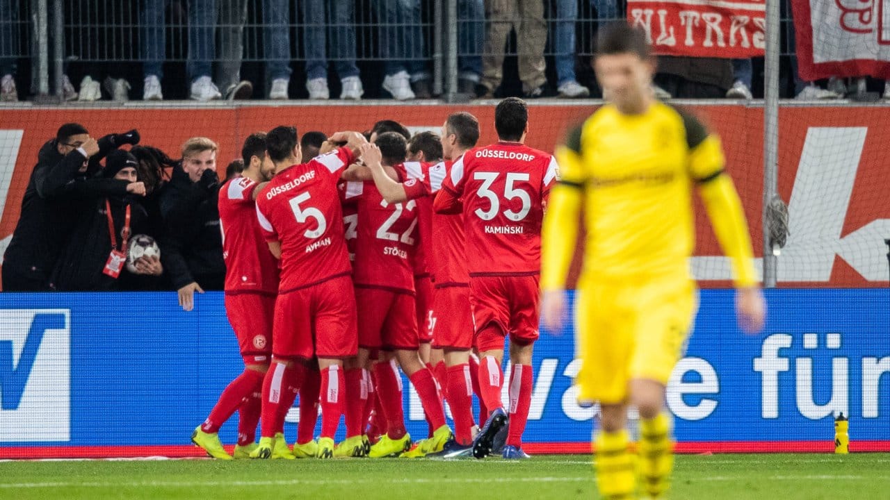 Die Düsseldorfer Spieler (l) freuen sich nach dem Treffer zum 2:0 gegen den BVB.