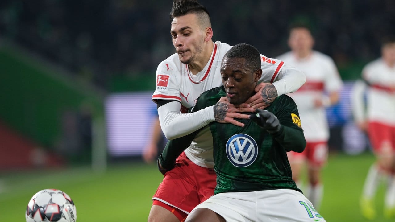 Anastasios Donis (hinten) vom VfB Stuttgart klammert beim Kampf um den Ball gegen Wolfsburgs Jerome Roussillon.