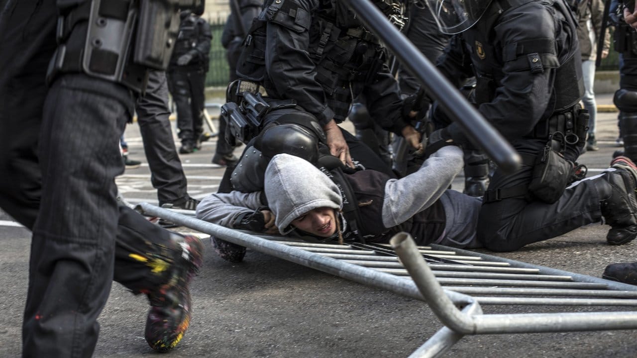 Die Polizei nimmt einen jungen Demonstranten fest.