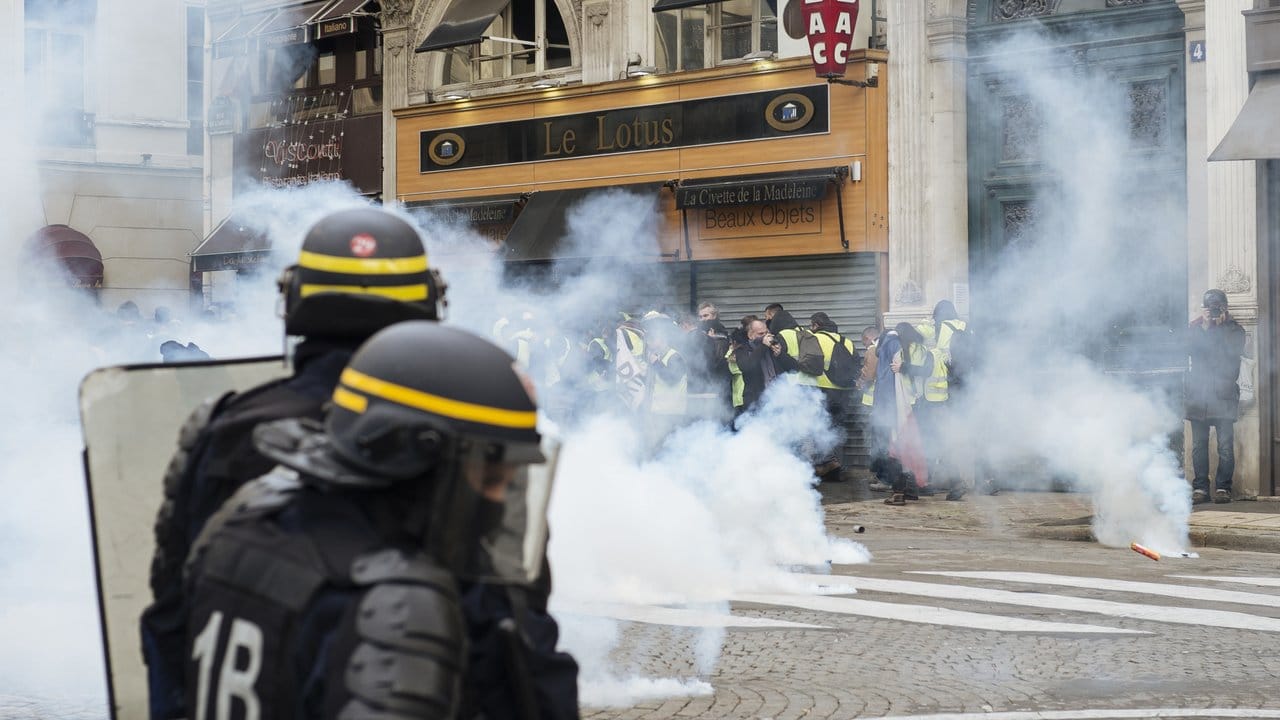 Polizisten feuern mit Tränengas auf "Gelbwesten"-Demonstranten nahe der Kirche "La Madeleine" in Paris.