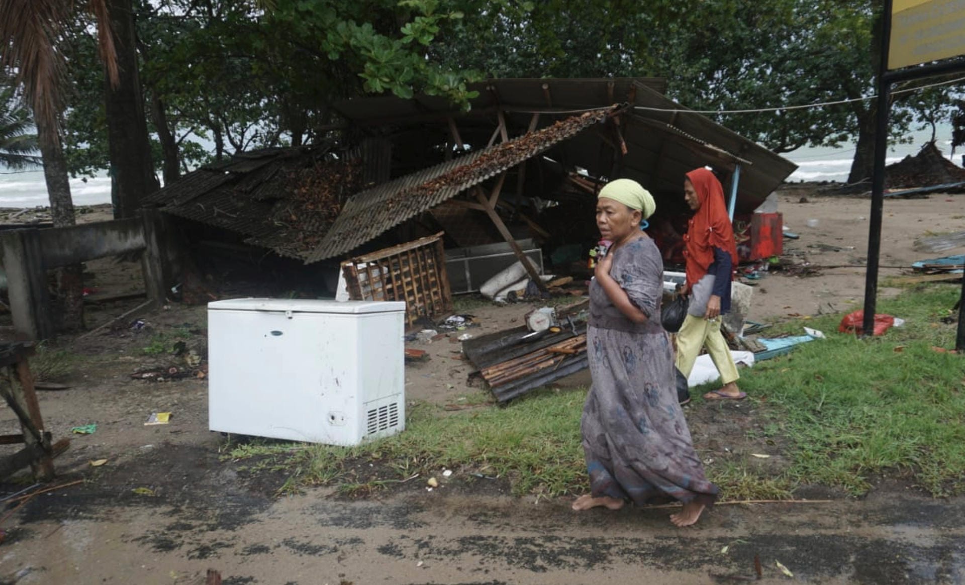 Bewohner betrachten die Schäden an Hütten, die in der Nähe des Strandes stehen. Viele Menschen haben all ihren Besitz verloren.