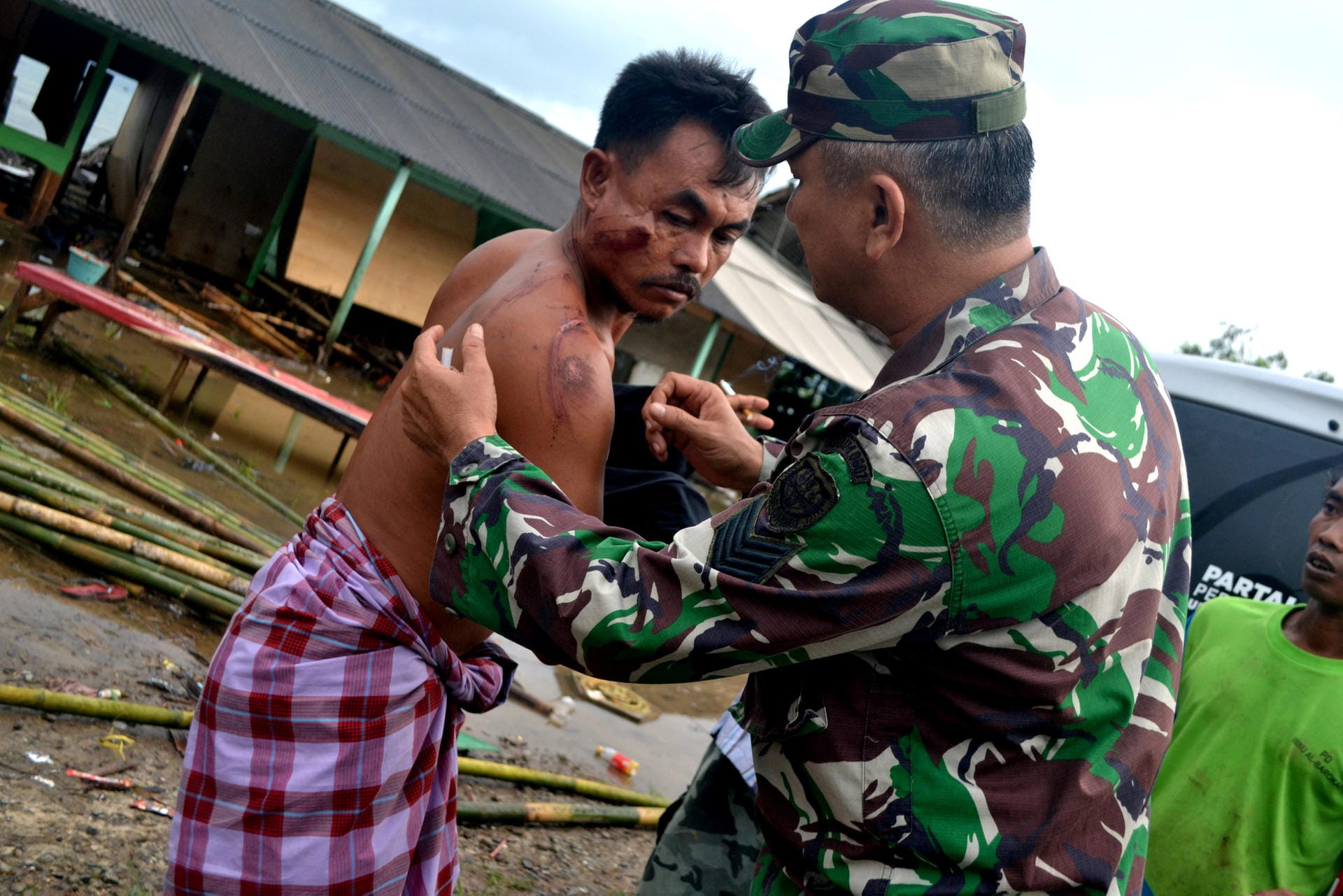 Ein Soldat behandelt einen verletzten Indonesier. Ob auch Touristen zu Schaden gekommen sind, war zunächst unklar.