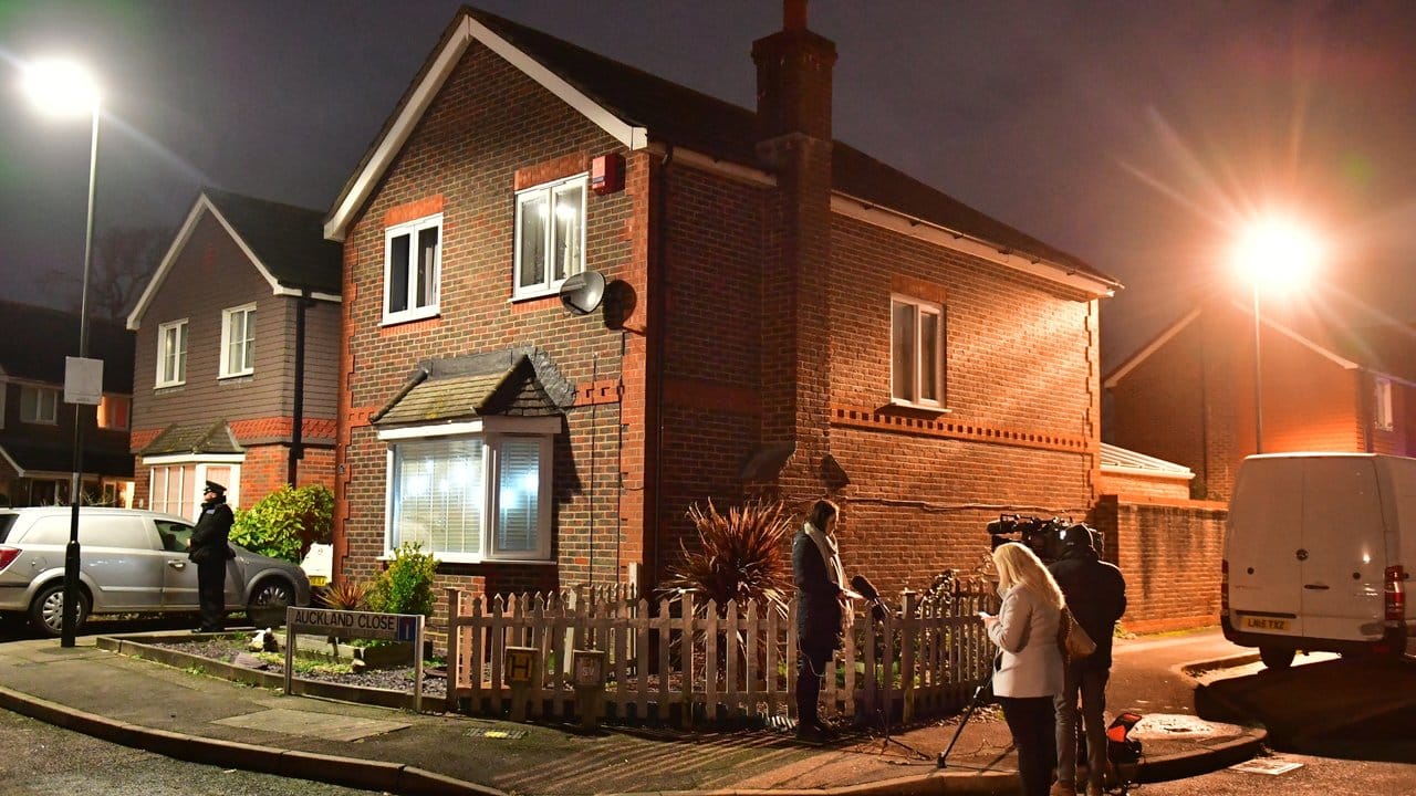 In Crawley stehen Polizisten und Medinvertreter vor einem Haus, das im Zusammenhang mit dem Drohnenzwischenfall durchsucht wurde.