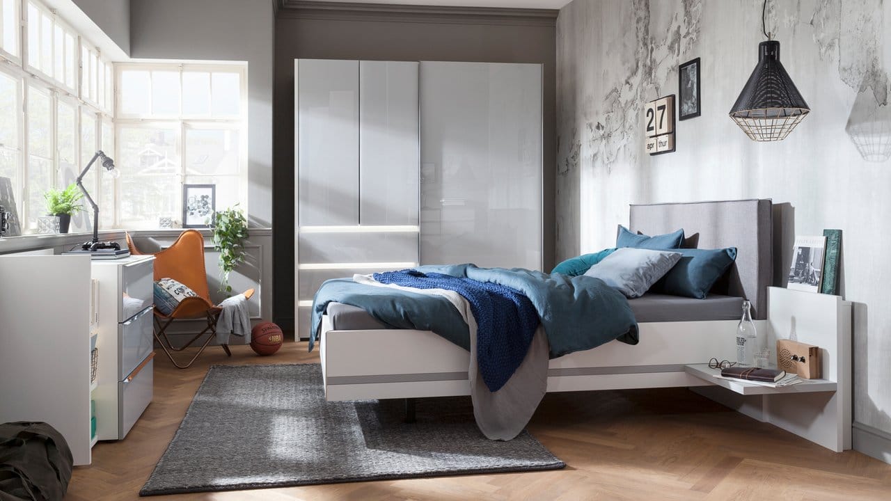 Viele Decken und Kissen, aber eine neutrale Farbgebung - so wird aus dem meist eher sterilen Schlafzimmer eine Wohlfühloase.