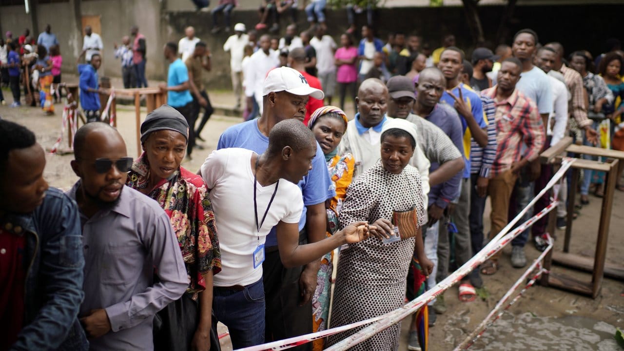 Wähler warten vor einem Wahllokal in Kinshasa auf die Abgabe ihres Stimmzettels.
