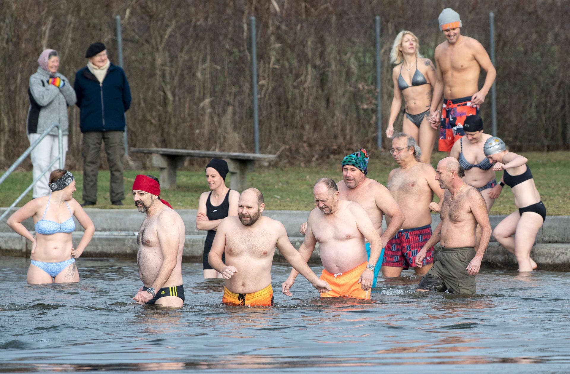 In Moosseedorf in der Schweiz steigen Schwimmer steigen beim traditionellen Silvesterbaden in den rund vier Grad kalten Moossee.