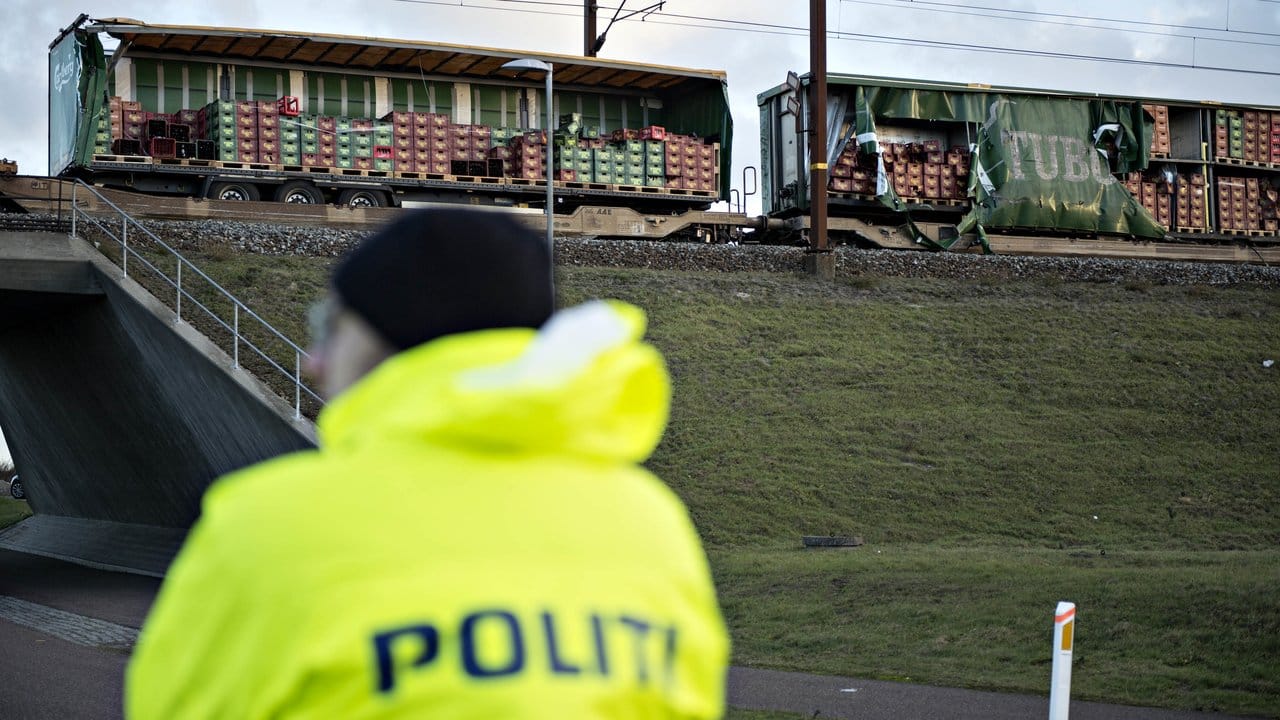Ein Polizist steht vor einem beschädigten Güterzug, nahe der Brücke über den Großen Belt bei Nyborg.
