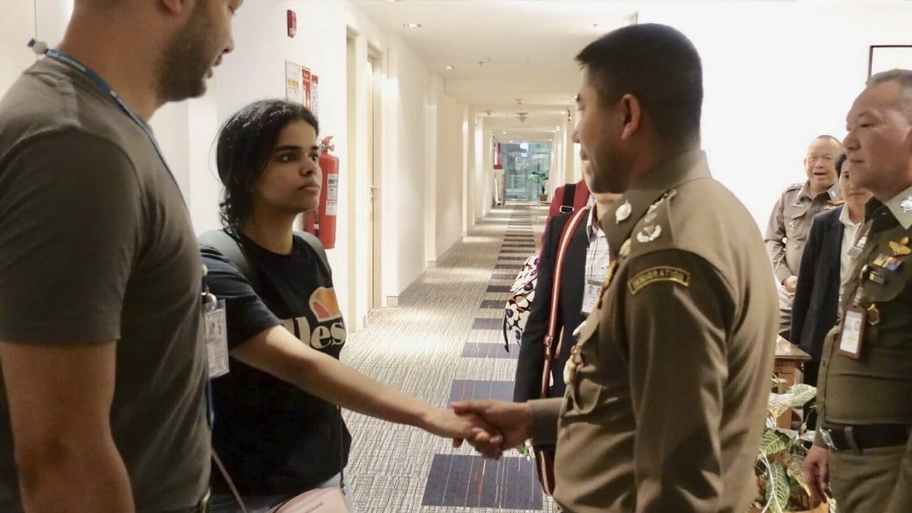 Rahaf Mohammed al-Kunun begrüßt den Chef der Einwanderungspolizei von Thailand am internationalen Flughafen in Bangkok.