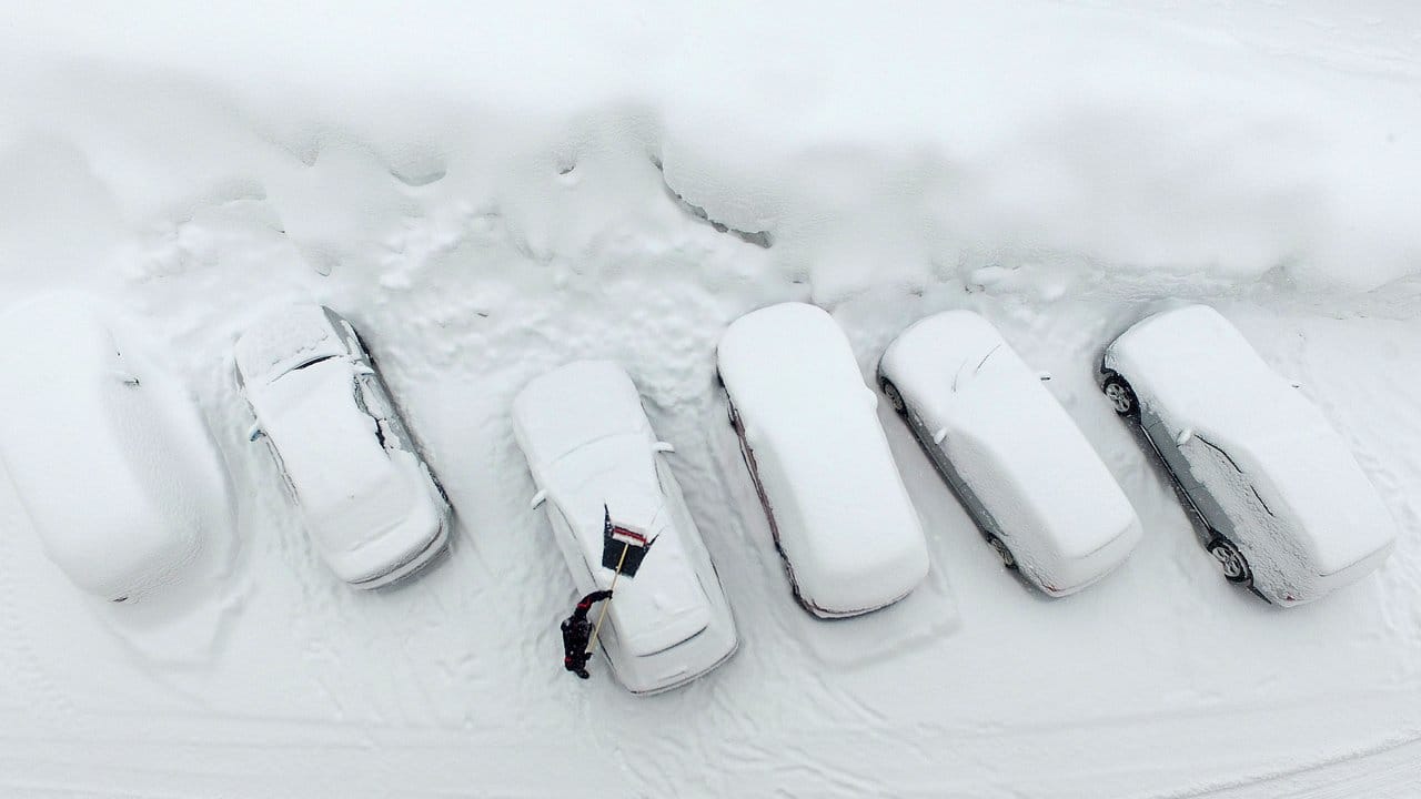 Ausgrabungen: Ein Mann befreit in Ramsau am Dachstein sein Auto von Schnee.