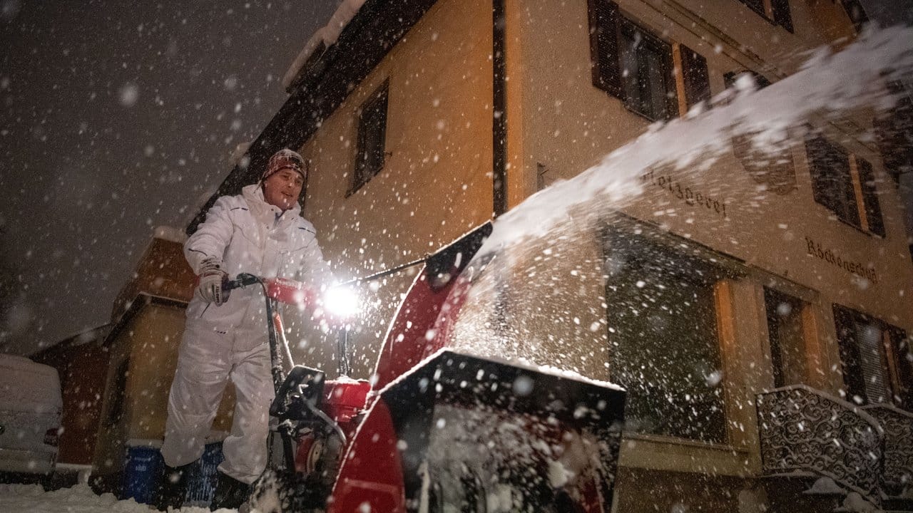 Der Inhaber einer Metzgerei in Bayer befreit seinen Hof mit einer Fräse vom Schnee.