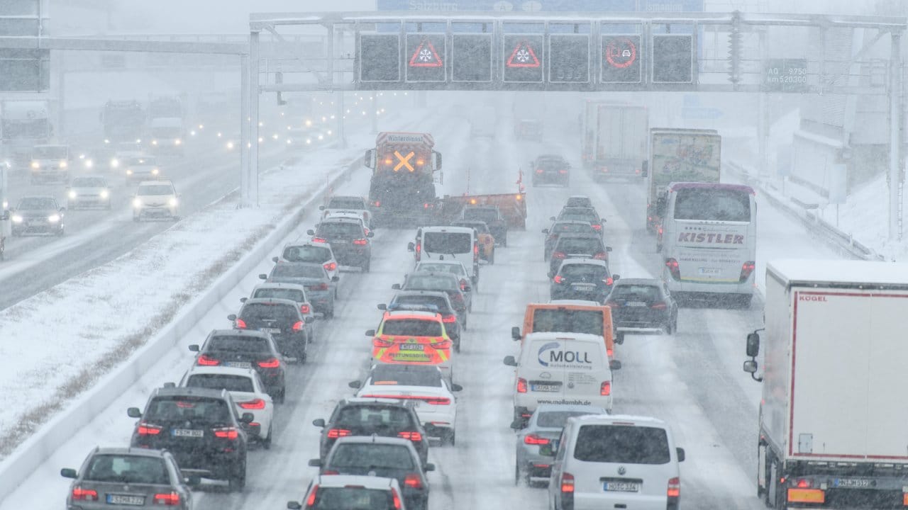 Hinter einem Räumfahrzeug staut sich auf der Autobahn 9 im Schneetreiben der Verkehr.