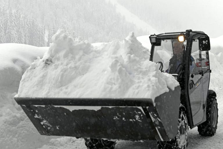 Ein Bagger befreit eine Straße im österreichischen Niedertauern vom Schnee.