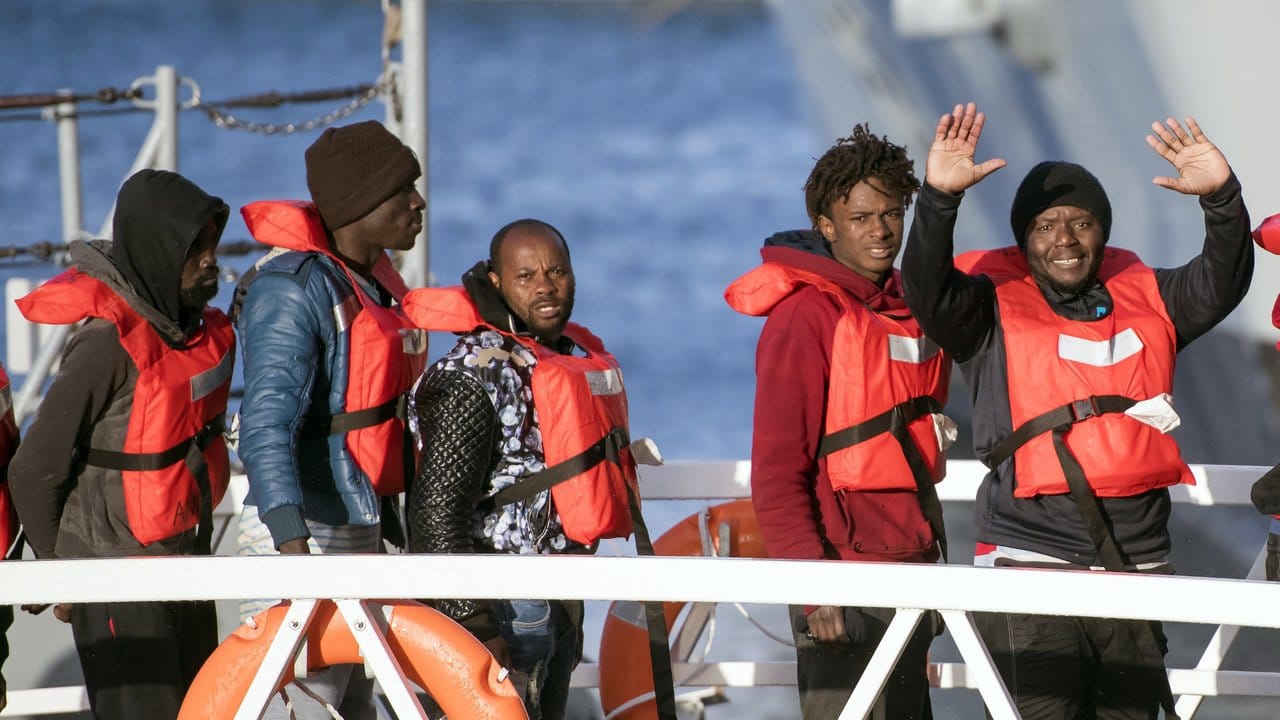 Migranten winken, als sie eins der deutschen Rettungsschiffe im Hafen von Pieta auf Malta verlassen dürfen.