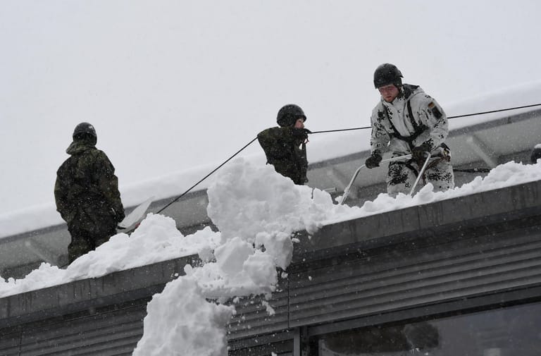 Soldiers of the German armed forces Bundeswehr remove snow from the roof of a high school building in Berchtesgaden