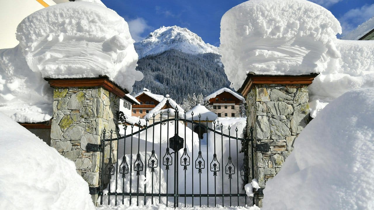 Schnee türmt sich an einer Einfahrt zu einem Grundstück im Salzburger Land.