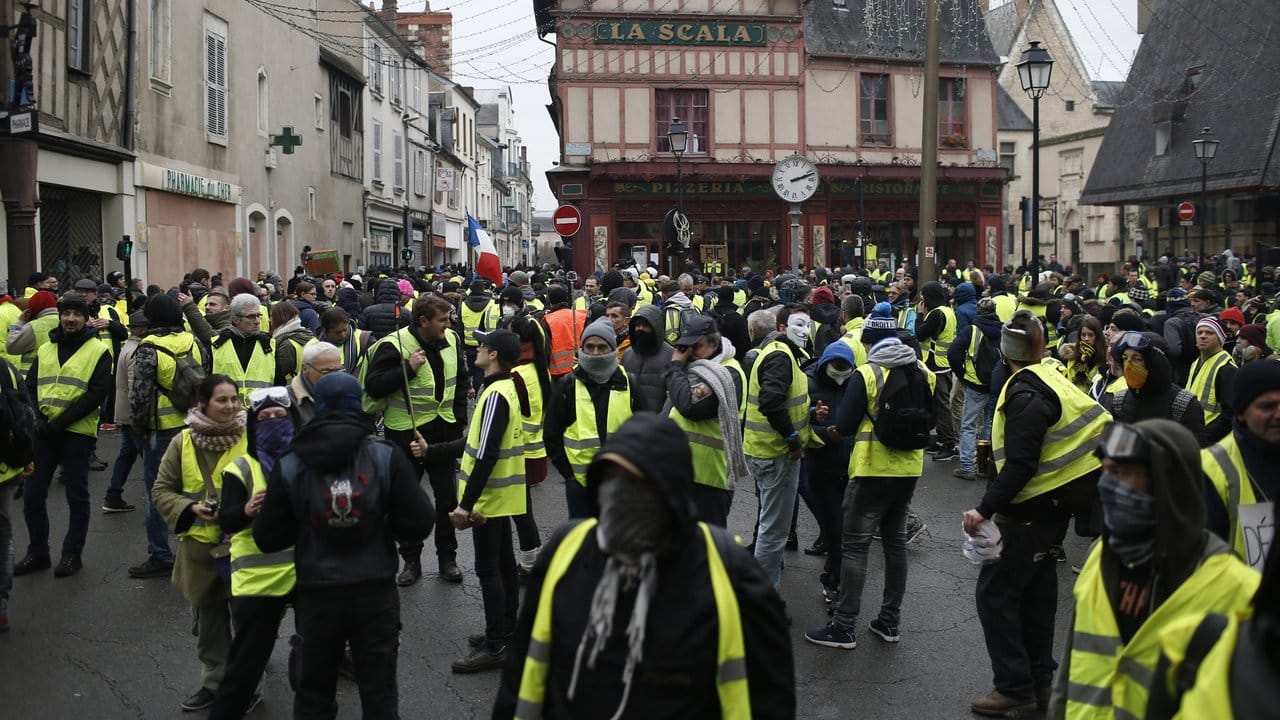 In Bourges versammeln sich Teilnehmer einer Demonstration der "Gelbwesten" auf einem Platz.