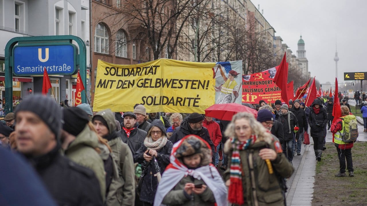 Teilnehmer des Demonstrationszugs tragen ein Transparent mit der Aufschrift "Solidarität mit den Gelbwesten!".