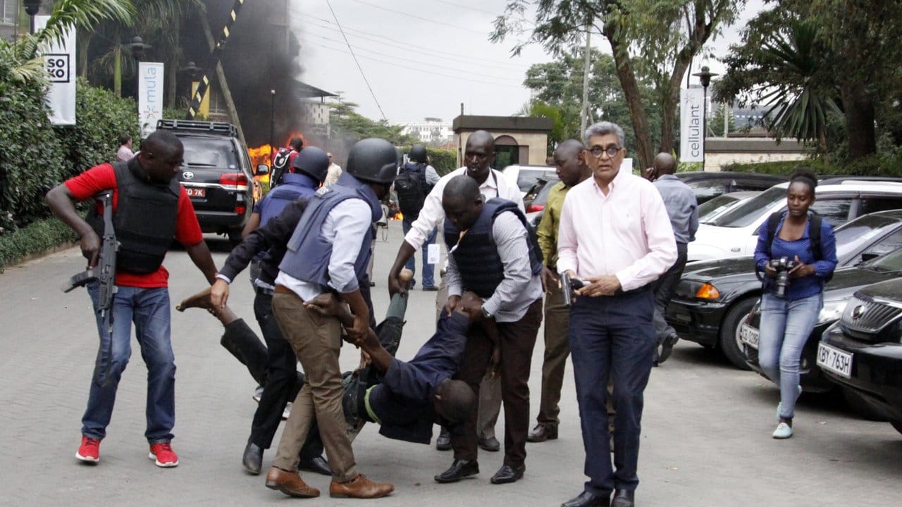 Sicherheitskräfte helfen einem Mann am Schauplatz der Explosion in Kenias Hauptstadt Nairobi.
