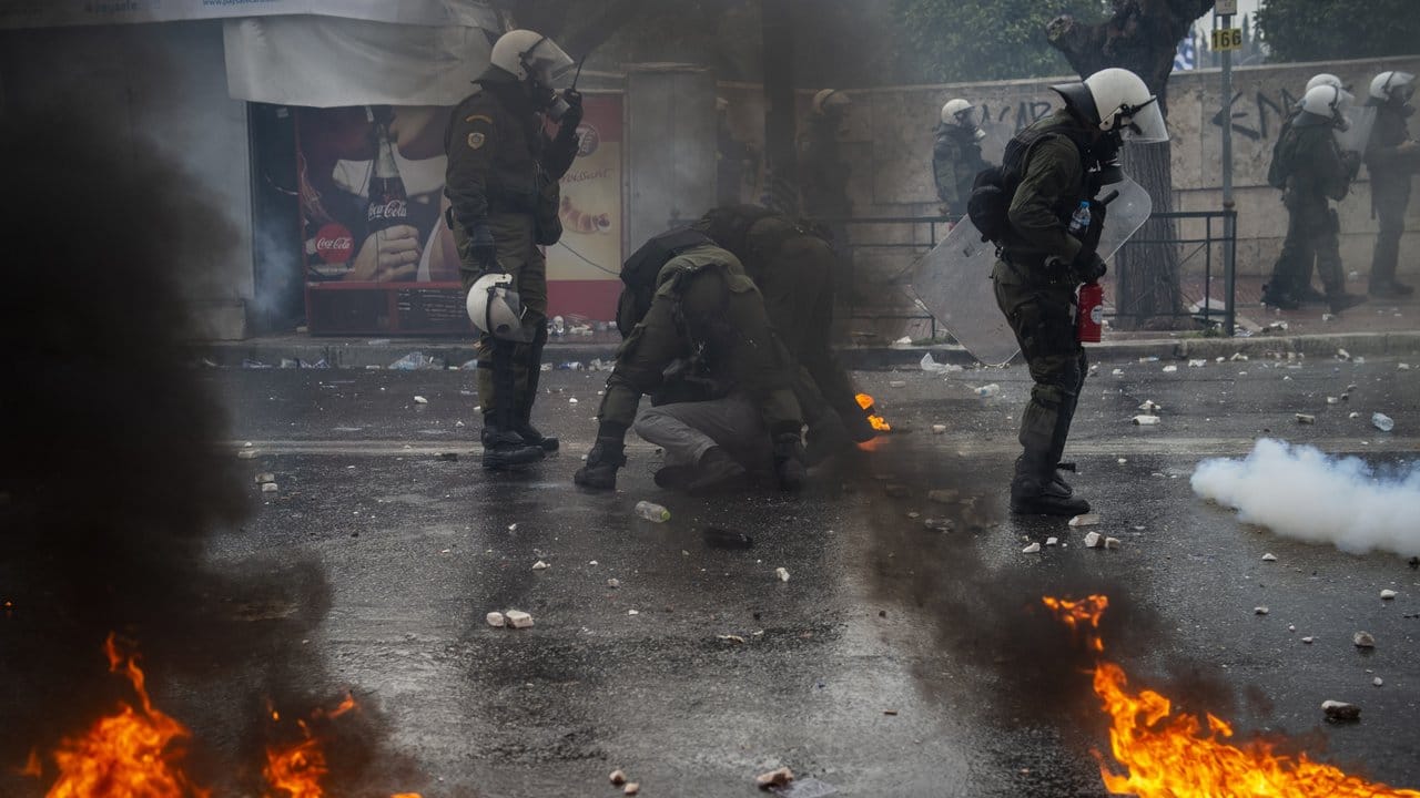 Bereitschaftspolizisten drücken in Athen einen Demonstranten zu Boden. Bereitschaftspolizisten drücken in Athen einen Demonstranten zu Boden.