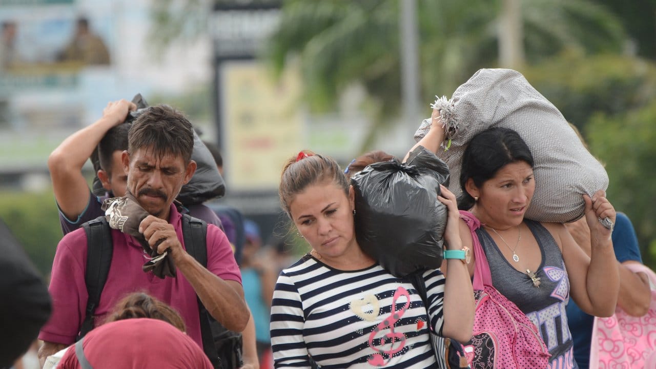 Venezolaner tragen ihre in Kolumbien getätigten Einkäufe über die Grenzbrücke zurück nach Venezuela.