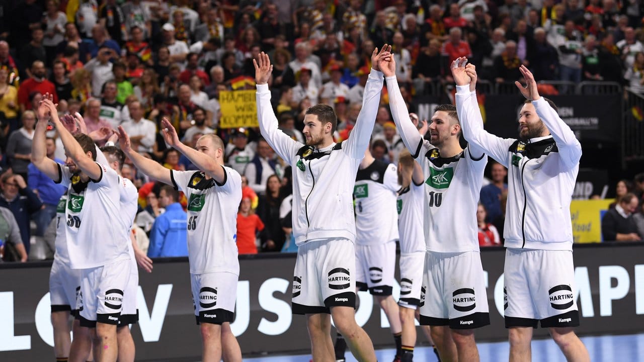 Deutschlands Handballer feiern mit dem Publikum den Sieg über Spanien.