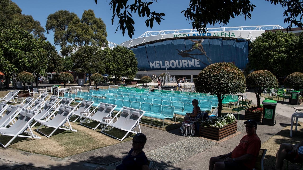 Zuschauer sitzen im Schatten von Bäumen während der Australian Open in Melbourne.