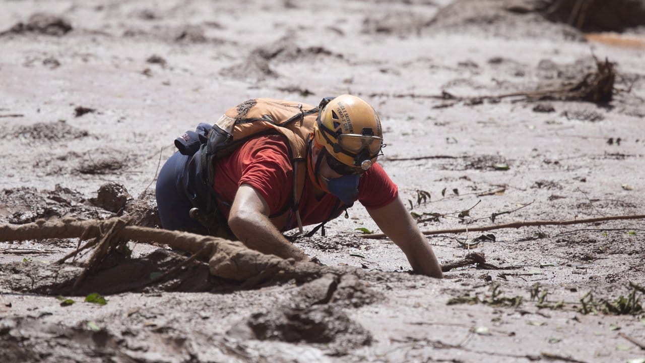 Ein Rettungshelfer arbeitet im Schlamm auf der Suche nach möglichen Opfer des Dammbruchs. Ein Rettungshelfer arbeitet im Schlamm auf der Suche nach möglichen Opfer des Dammbruchs.