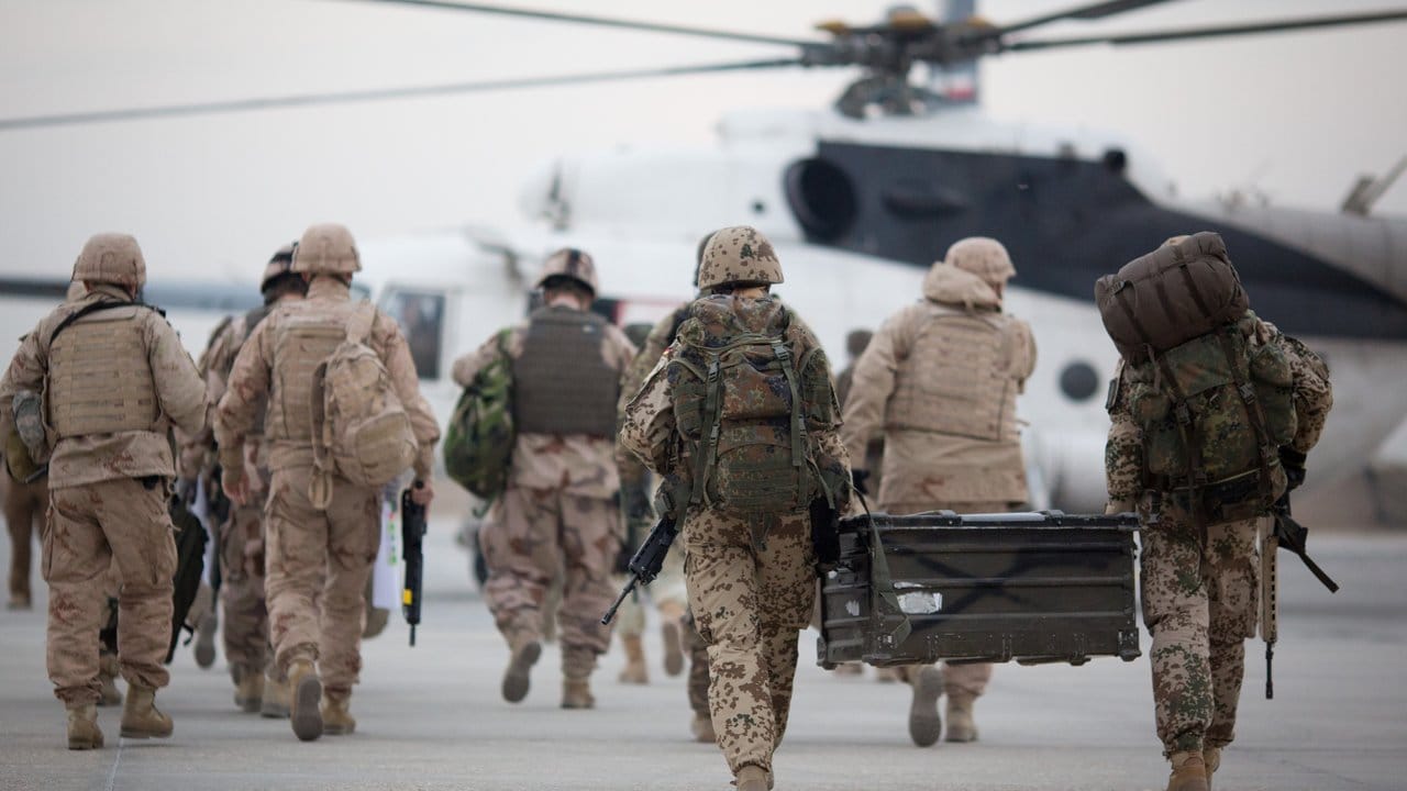 Bundeswehrsoldaten mit Feldkiste auf dem Weg zu einem Hubschrauber auf dem Flughafen in Masar-i-Scharif.