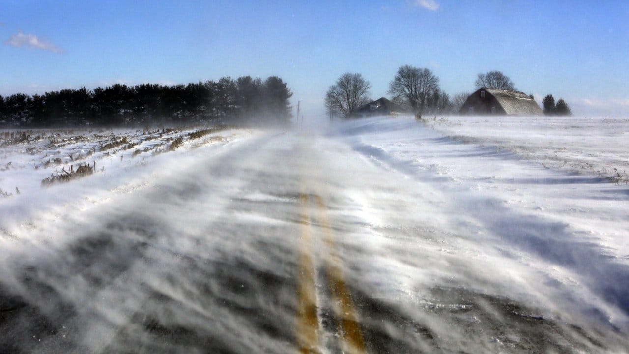 Schnee weht in Lancaster County in Pennsylvania über eine Straße.