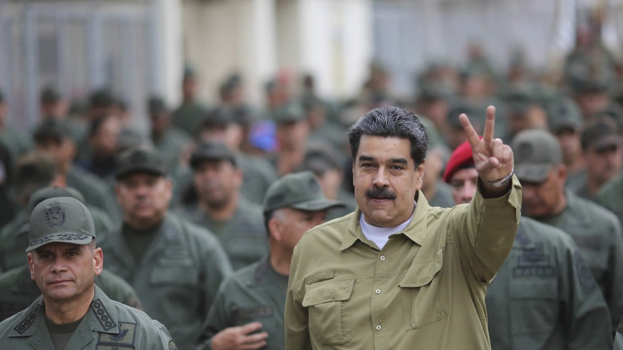 Umgeben von Soldaten zeigt Präsident Nicolás Maduro bei einem Truppenbesuch das Siegeszeichen.