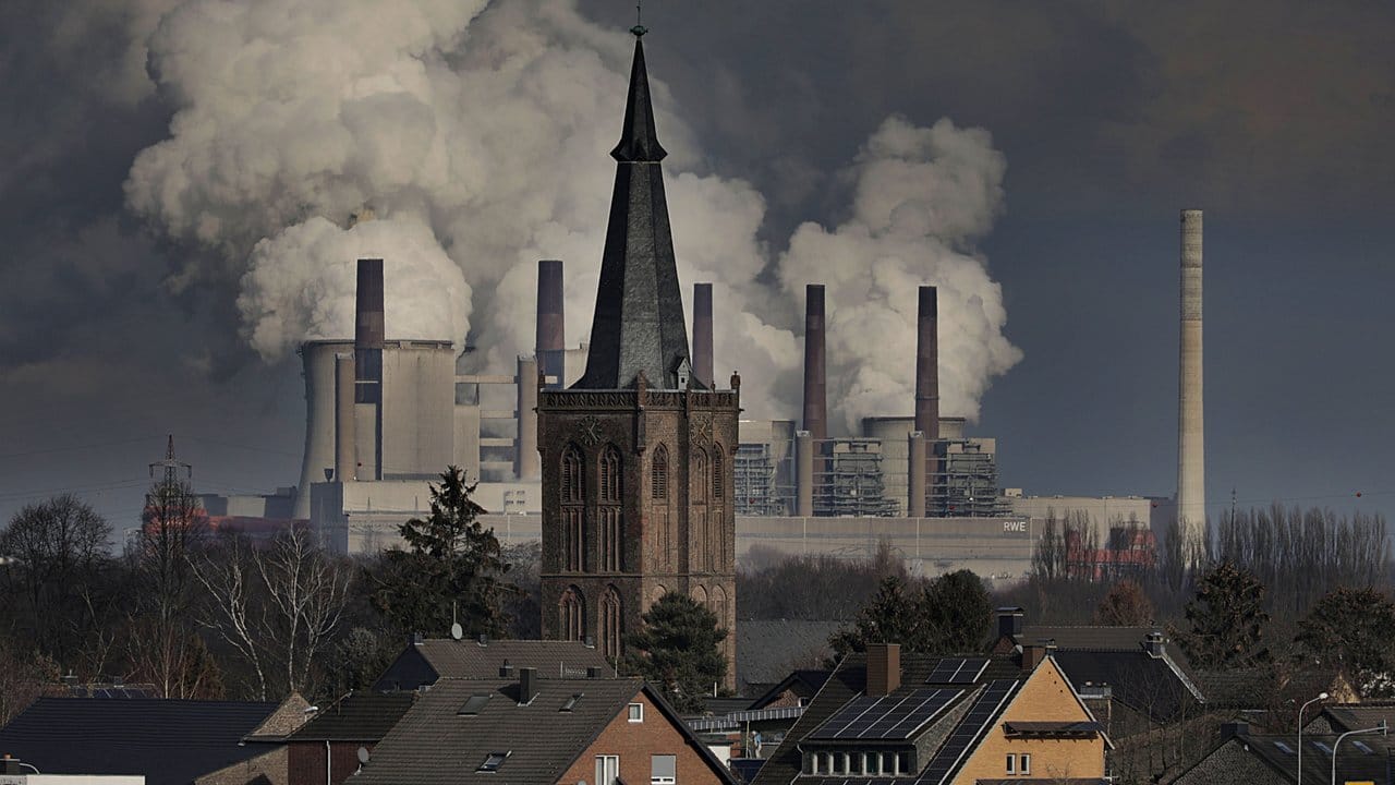 Rauch und Dampf steigen aus dem RWE Braunkohlekraftwerk Neurath hinter der St.