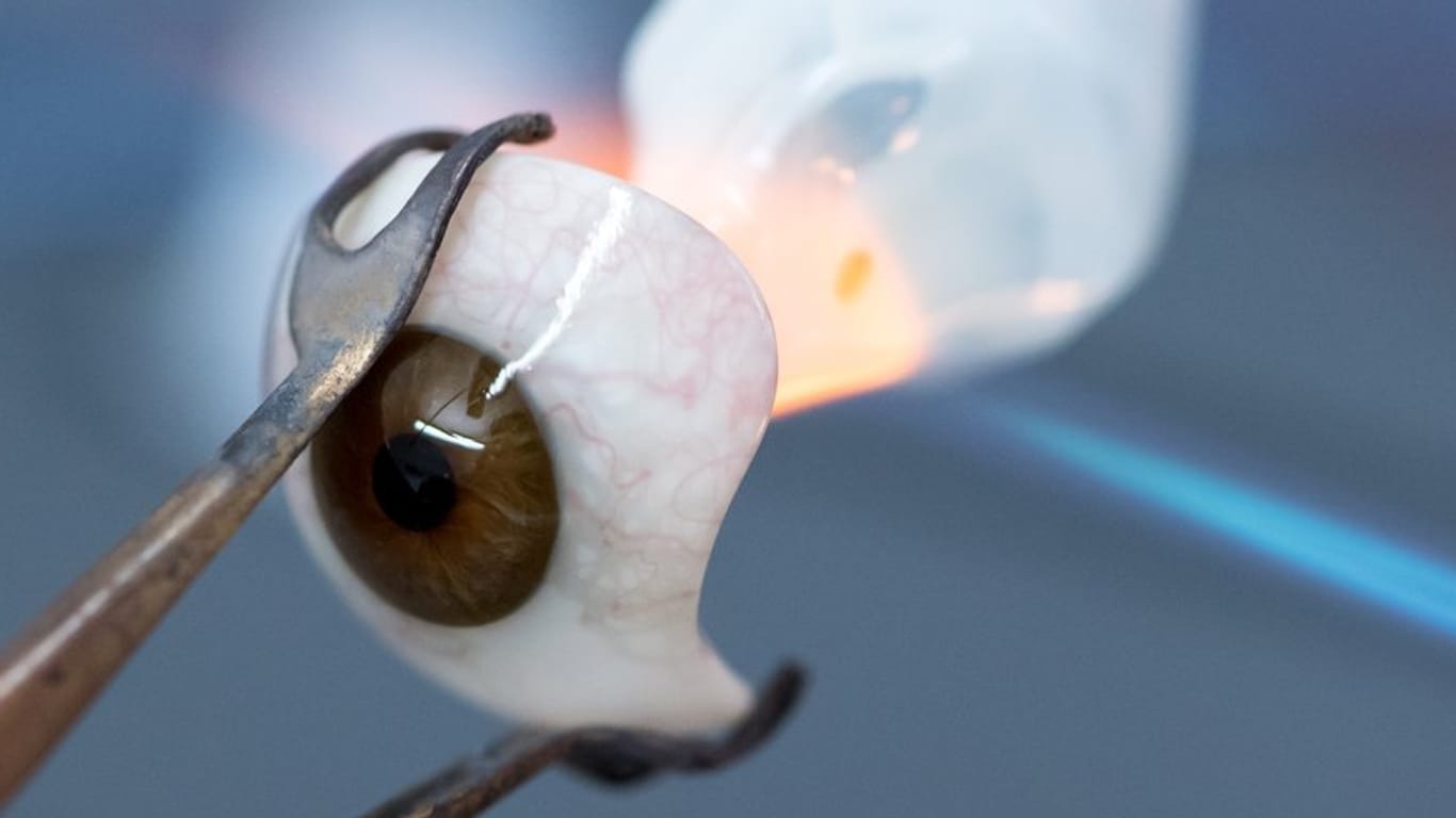 Eine Ocularistin am Institut für künstliche Augen formt aus Glas ein künstliches Auge. Eine Ocularistin am Institut für künstliche Augen formt aus Glas ein künstliches Auge.