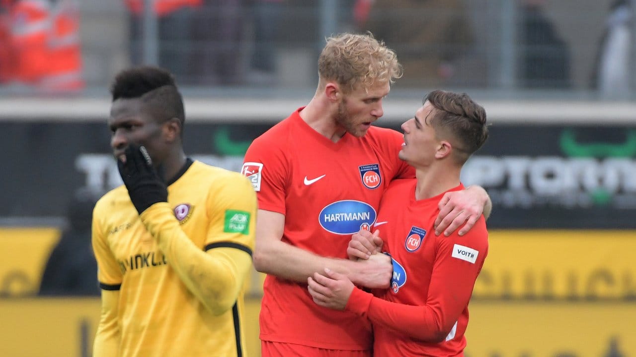 Heidenheims Nikola Dovedan (r) und Sebastian Griesbeck beglückwünschen sich neben Moussa Kone von Dynamo Dresden zum Sieg.