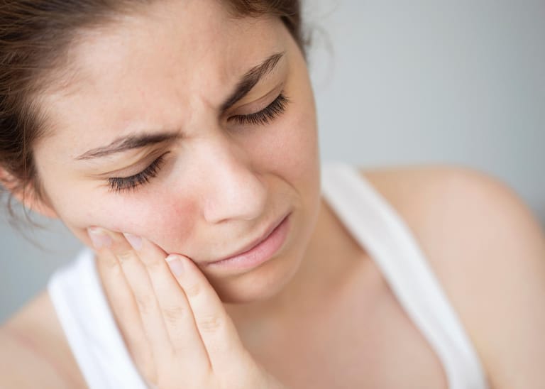 Frau mit Parodontitis: Chronische Entzündungen des Zahnbetts gelten als Hauptgrund für Zahnverlust.