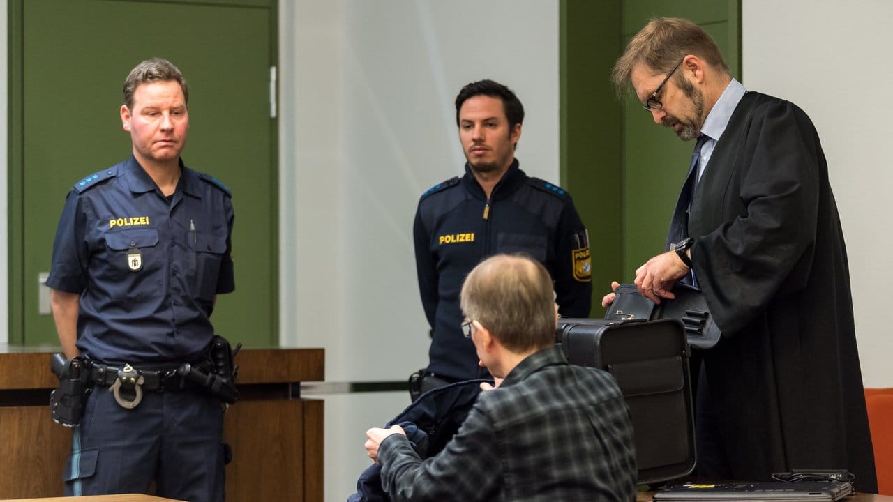 Der Angeklagte (M) sitzt in einem Saal des Landgerichts München II.