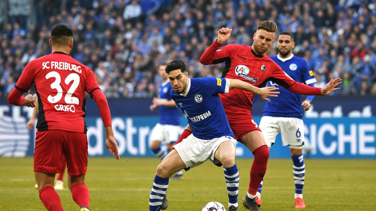 Schalkes Suat Serdar beim Zweikampf mit dem Freiburger Lucas Höler (r).