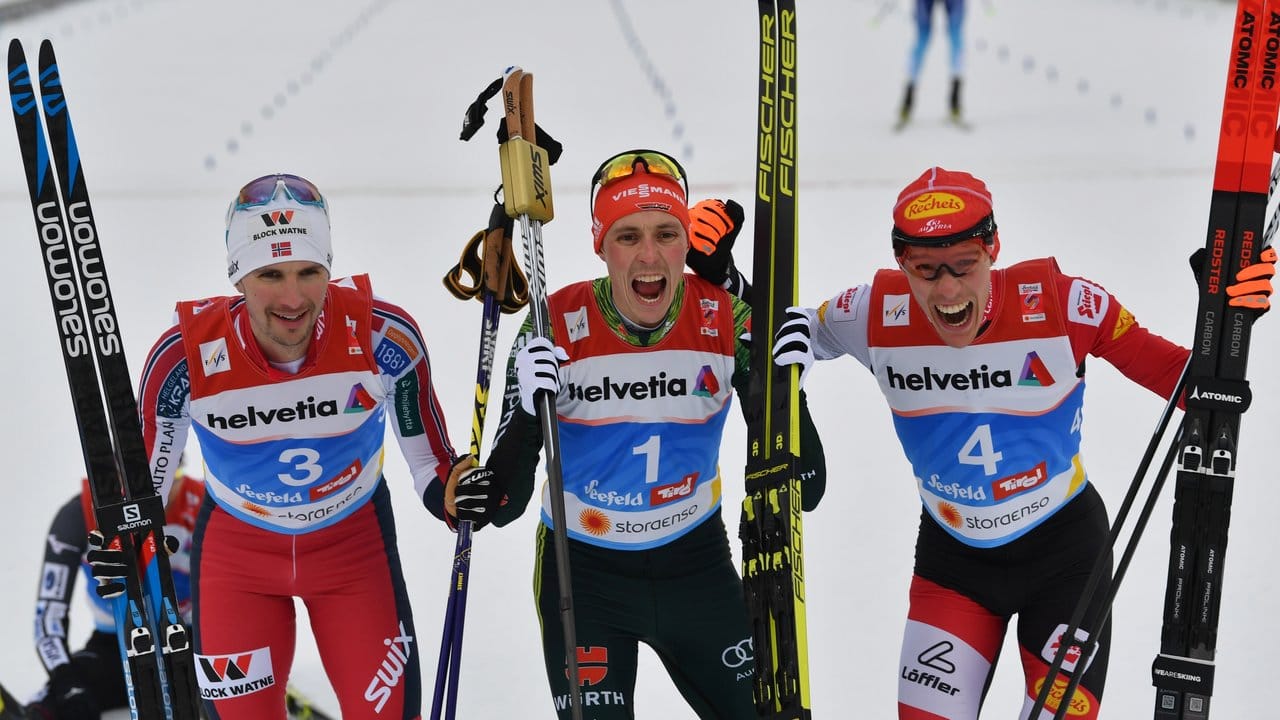 Eric Frenzel (M) feiert seinen Sieg mit dem Zweitplatzierten Jan Schmid (l) aus Norwegen und Franz Josef Rehrl aus Österreich.
