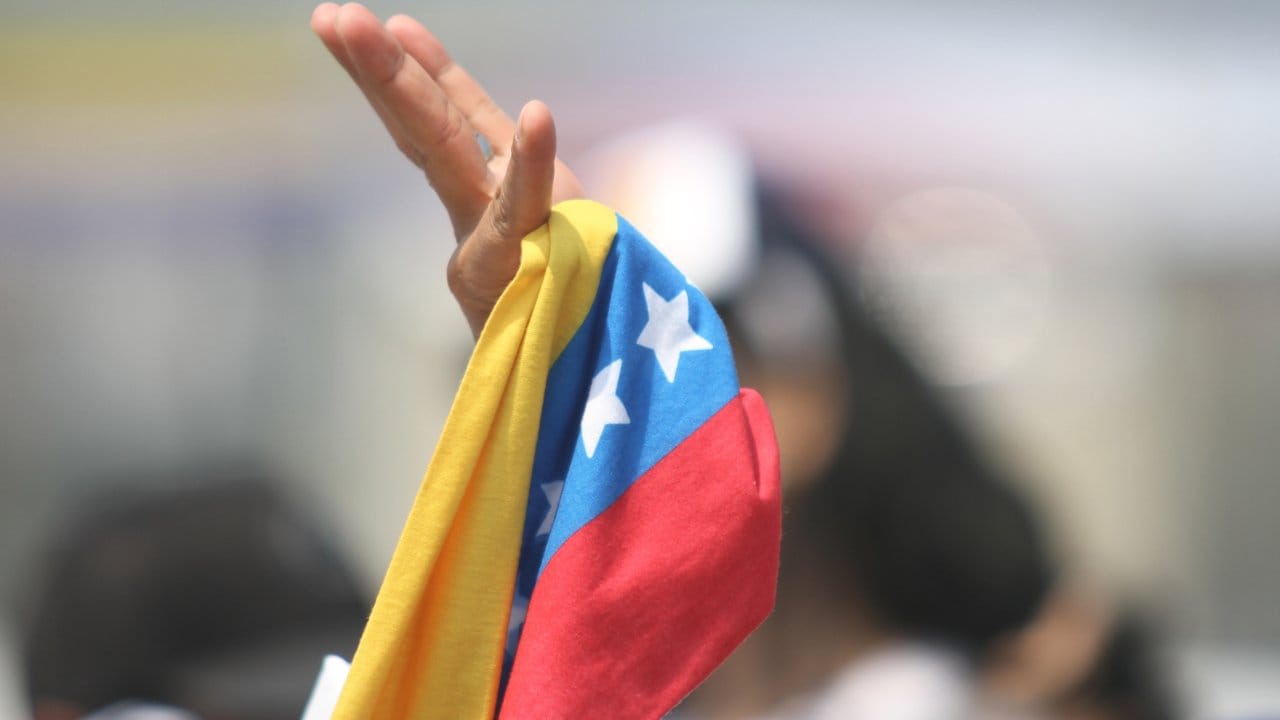 Ein Zuschauer schwenkt bei dem Benefizkonzert "Venezuela Aid Live" auf der kolumbianischen Seite der Grenzbrücke Tiendita eine Fahne.