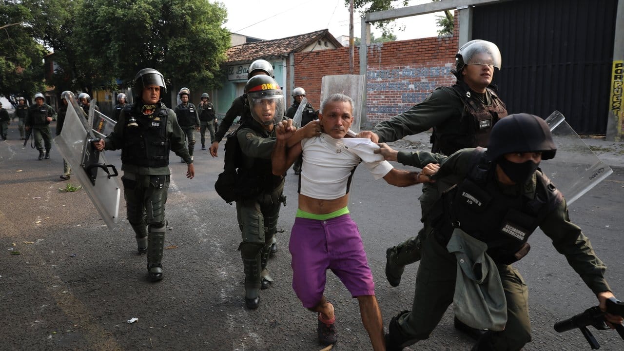 Ein Mann wird von Soldaten der Nationalgarde festgehalten.